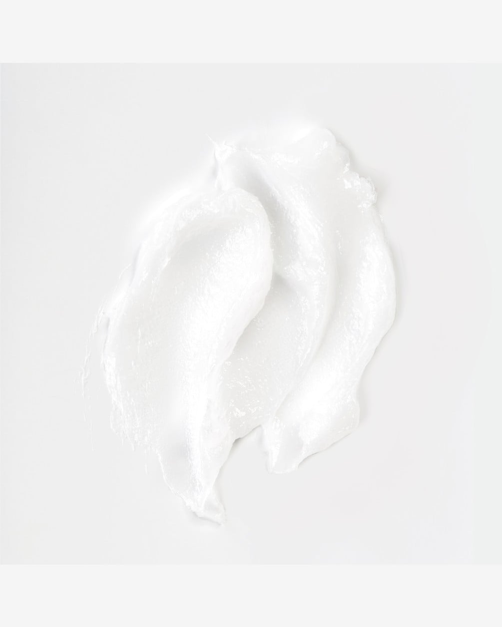 A top-down view of a thick, white swirl of the SpoiledChild A29 Shine Activator Hair Mask. The creamy texture of the product is displayed against a clean, plain white background, showing soft peaks and a smooth consistency.