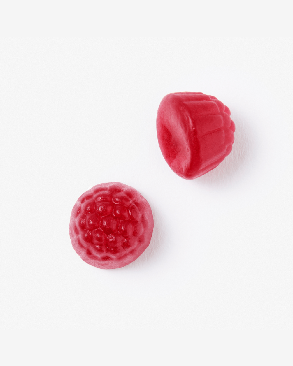 Two red, raspberry-shaped gummy L30 supplements are shown in a close-up overhead shot against a clean white background. One gummy is positioned face-up, while the other sits slightly above it on its side.