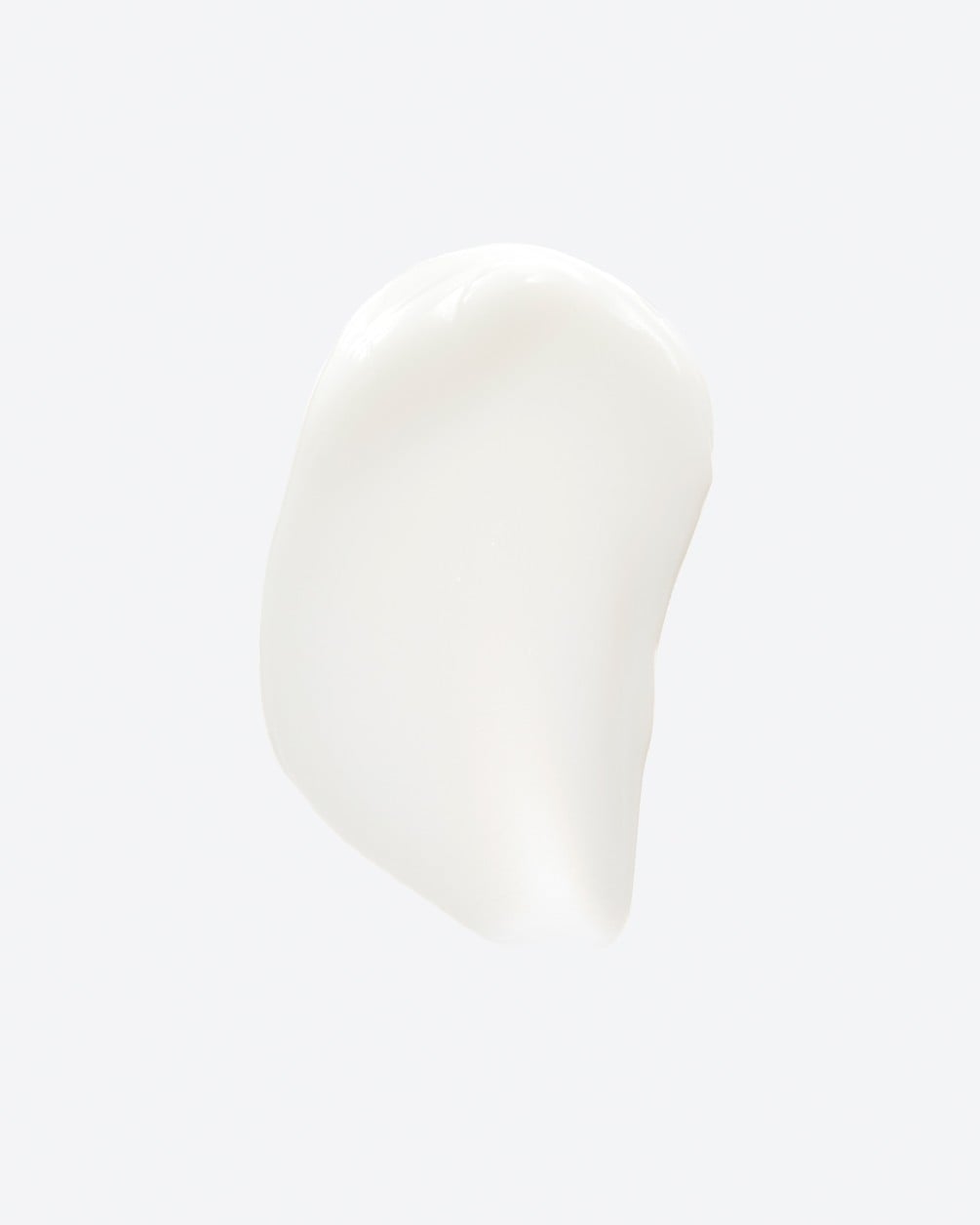 A texture swatch of smooth, opaque white cream shown as a vertical smear on a plain white background.