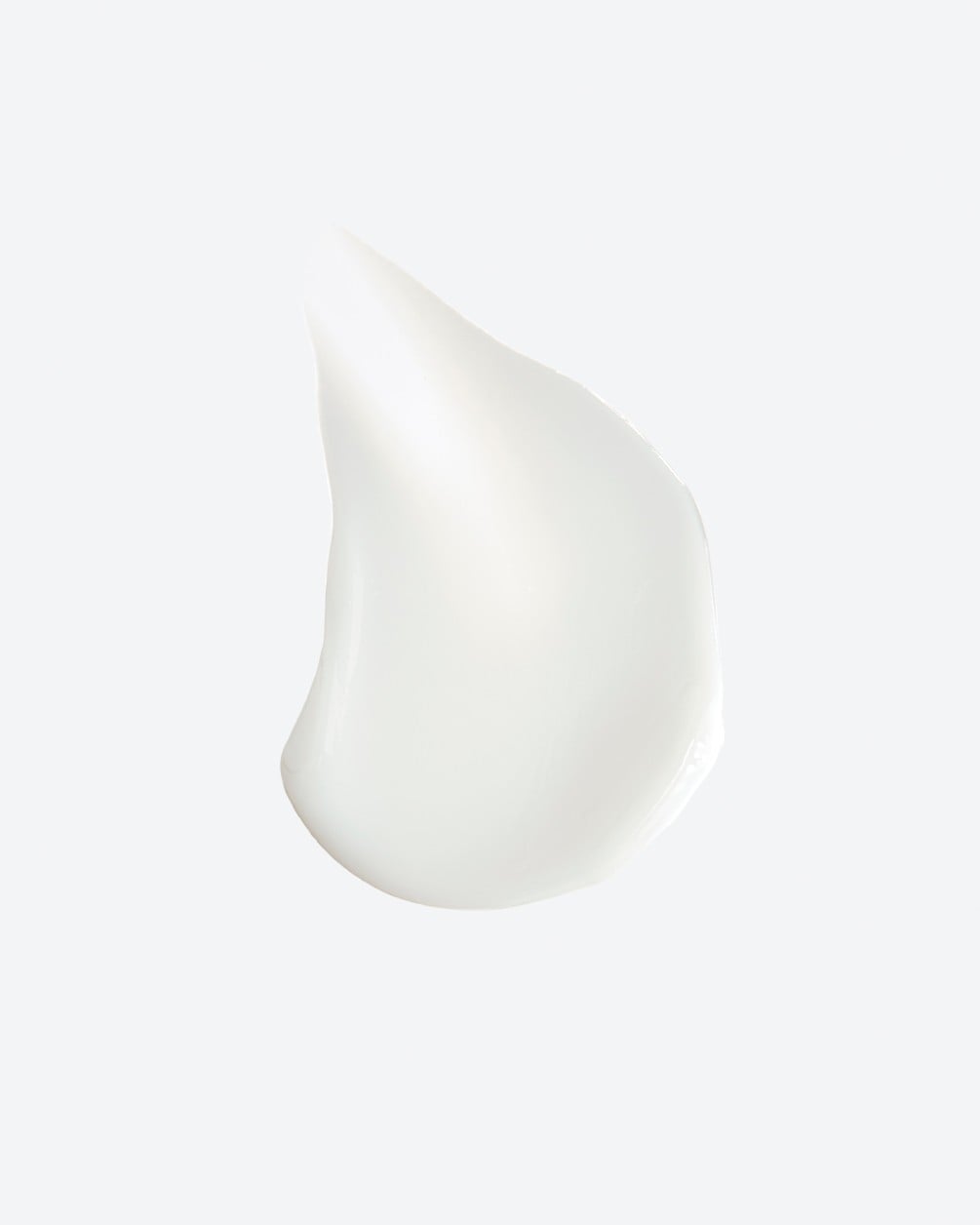 A texture swatch of smooth, opaque white cream shown as a short vertical smear on a plain white background.