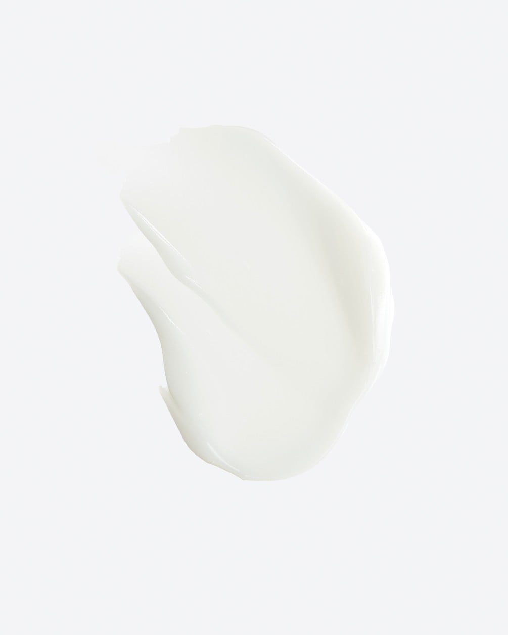 A short vertical texture swatch of smooth white skincare cream on a white background.
